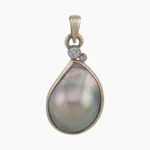 Pendant with a natural abalone pearl from Mendcino, California. Pear-shaped, measuring 18 x 13mm set in 14-karat yellow gold with 2 round VS1G accent diamonds one measuring 2.4mm, 0.05-carats and the second measuring 1.7mm 0.02-carats, both set in a 14-karat white gold bezel at the top.