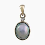 Pendant with a natural abalone pearl from Mendcino, California. Oval-shaped, measuring 11 x 8mm set in 14-karat yellow gold with a single 2.4mm round VS1G 0.05-carat accent diamond at the top.