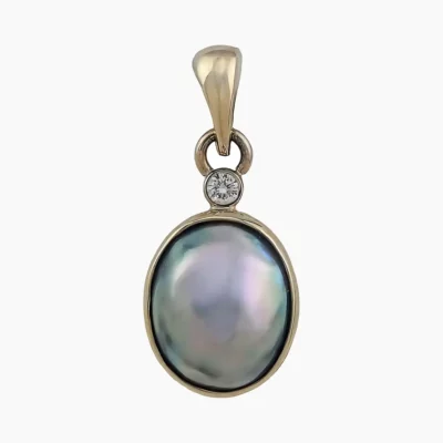 Pendant with a natural abalone pearl from Mendcino, California. Oval-shaped, measuring 11 x 8mm set in 14-karat yellow gold with a single 2.4mm round VS1G 0.05-carat accent diamond at the top.