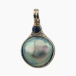 Pendant with a natural abalone pearl from Mendocino, California measuring 14 mm set in 14-karat yellow gold, accented with a 0.14-carat 3mm round Ceylon sapphire at the top.