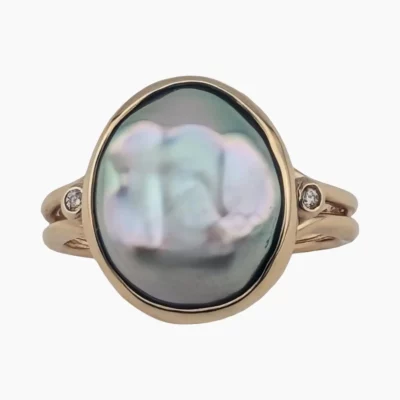 Ring with a natural abalone oval pearl measuring 13 x 11mm from Mendocino, California, set in 14-karat yellow gold with two 0.04 (TW) 1.8mm round VS1G diamonds on each side set in 14-karat white gold.