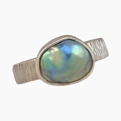 Ring with natural abalone pearl from Mendocino, California. Freeform-shaped measuring 12 x 10mm. Set in sterling silver.
