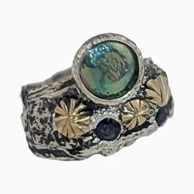 Ring with a natural abalone pearl measuring 8mm from Mendocino, California set in sterling silver with hand engraved 18-karat yellow gold accents and two round sapphires (Total weight 0.12-carats).