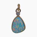Pendant featuring a 2.65-carat freeform opal measuring 12 x 5mm Coober Pedy, Australia. Set in 14-karat yellow gold with a round 2.4mm 0.05-carat VS1G diamond accent at the top.