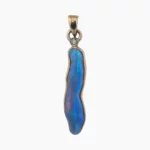 Pendant with a 2.24-carat freeform shaped opal from Coober Pedy measuring 24 x 6mm set in solid 14-karat yellow gold with a 2mm round 0.03-carat VS1G diamond accent.
