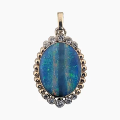 Pendant featuring a 4.22-carot oval opal from Andamooka Austrailia, measuring 18 x 14mm. Set in 14-karat yellow gold with 10 2mm round VS1G diamonds (Total weight 0.32-carats) bezel set on each side.