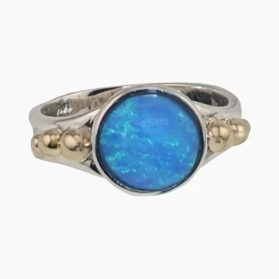 Ring featuring a round 1.47-carat opal from Coober Pedy, Australia measuring 10mm set in sterling silver with solid 14-karat yellow gold accents.
