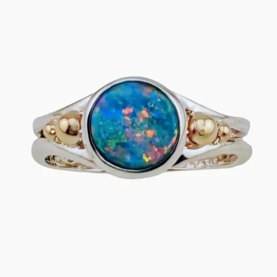 Ring featuring a 9mm round 1.68-carat Australian Lambina opal with exceptional color play. Set in sterling silver and accented with solid 14-karat yellow gold.