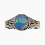 Ring with a round 1.88-carat opal from Lambina, Australia measuring 9mm set in sterling silver with 3 solid 14-karat yellow gold accents on each side.