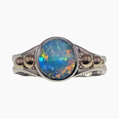 Ring with a round 1.88-carat opal from Lambina, Australia measuring 9mm set in sterling silver with 3 solid 14-karat yellow gold accents on each side.