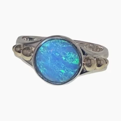 Ring featuring a round1.68-carat opal from Coober Pedy, Australia measuring 10mm set in sterling silver with solid 14-karat yellow gold accents.
