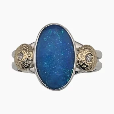 Ring with oval 2.94-carat opal measuring 13.5 x 8mm from Coober Pedy, Australia. Set in sterling silver with solid 18-karat gold accents, flush set with two 1.7mm round 0.04-carat VS1G quality diamonds.