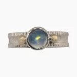 A Burmese 1.5-carat moonstone ring featuring a 6mm round stone set in sterling silver with solid 14-karat yellow gold accents.