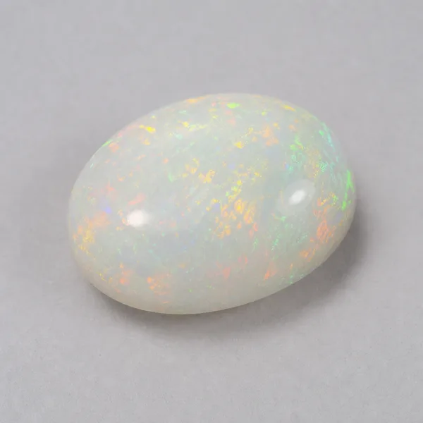 Loose light opal cabochon with a pale white body and softer play of color