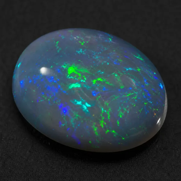 Loose dark opal cabochon with a medium gray body and visible blue and green play of color